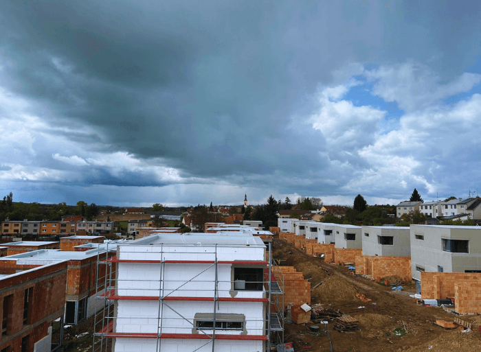 Dronové záběry a detaily hotových plochých střech z PVC fólie a moderních šedých fasád na projektu Rezidence Lipové sady v Rousínově od firmy Mister stav s.r.o.. Fotografie zachycují precizní zpracování hydroizolace a zateplení celého komplexu novostaveb.