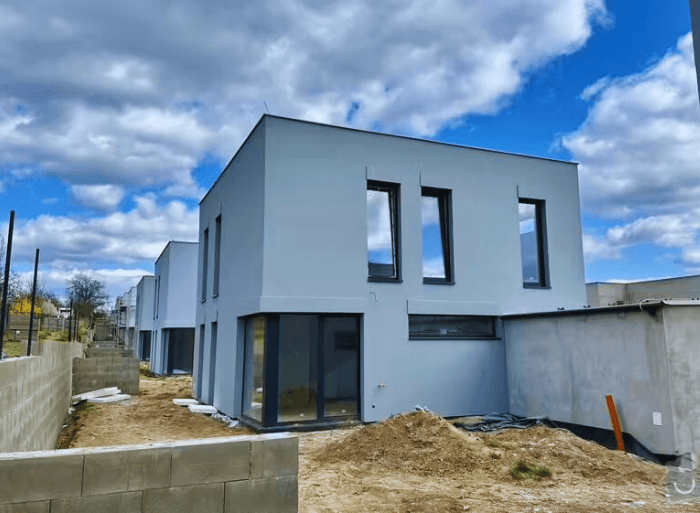 Dronové záběry a detaily hotových plochých střech z PVC fólie a moderních šedých fasád na projektu Rezidence Lipové sady v Rousínově od firmy Mister stav s.r.o.. Fotografie zachycují precizní zpracování hydroizolace a zateplení celého komplexu novostaveb.