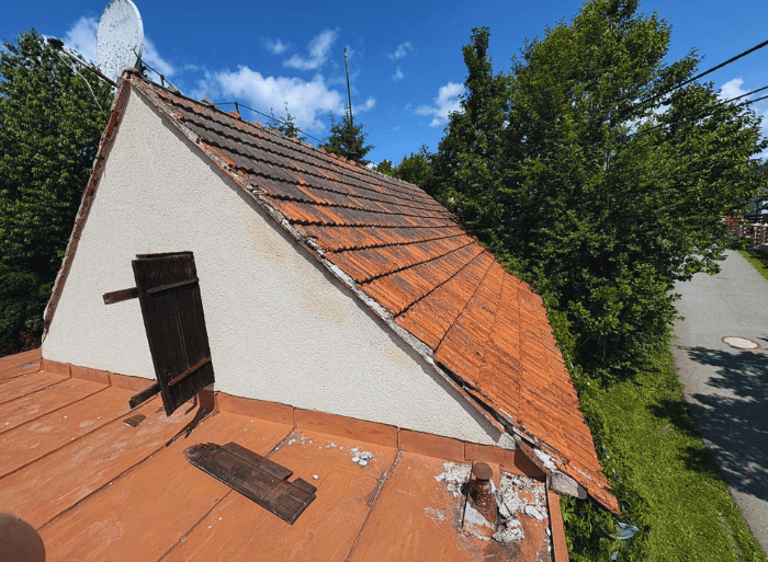 Komplexní rekonstrukce rodinného domu v Židlochovicích od firmy Misterstav. Fotografie zachycují výměnu sedlové střechy za novou skládanou krytinu, pokládku izolace a svařování PVC fólie na ploché terase a realizaci nové zateplené bílé fasády.