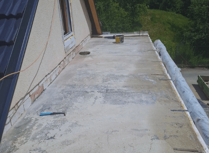 Komplexní rekonstrukce rodinného domu v Židlochovicích od firmy Misterstav. Fotografie zachycují výměnu sedlové střechy za novou skládanou krytinu, pokládku izolace a svařování PVC fólie na ploché terase a realizaci nové zateplené bílé fasády.